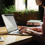 Woman typing on laptop in cafe