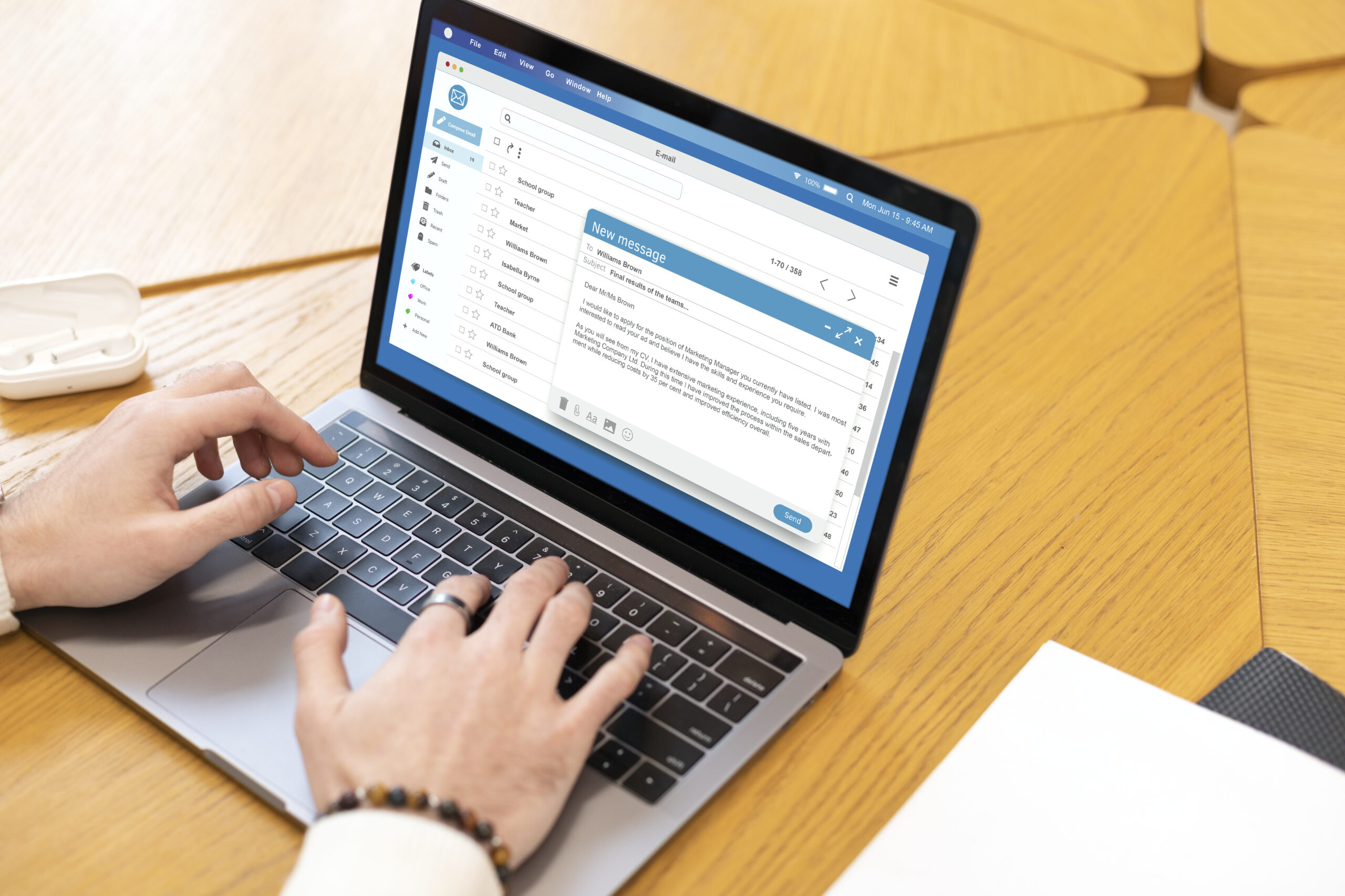 Hands typing an email on laptop